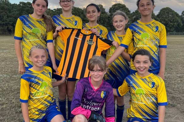 Edenthorpe U12 Girls holding the Doncaster Schools football top.