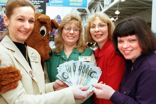 Asda worker Joan Umpleby (dressed as a bear), Doncaster Asda customer service manager Wendy Taylor (left), and Asda employee Jan Rooke present cheques and cash to the value of £910 to Patricia Revell and Jackie Talbot, chairman  and secretary/treasurer respectively of Children with Autism pictured back in 1998