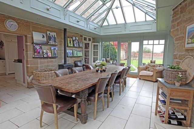 This Amdega conservatory/dining room has door to the garden and the front area, a wood burning stove and also serves as a link to the barn.