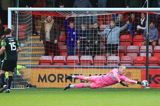 Doncaster Rovers goalkeeper Jonathan Mitchell gets down low to make a save.