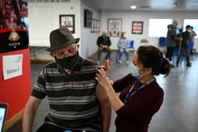 Dr Fiona Sheppard administers the Oxford/AstraZeneca Covid-19 vaccine to a patient at a temporary vaccination centre in the Keepmoat Stadium in Doncaster (Photo by Oli SCARFF / AFP) (Photo by OLI SCARFF/AFP via Getty Images)