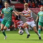 Doncaster's George Miller battles with Swindon's Tom Clayton.