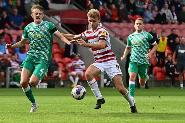 Doncaster's George Miller battles with Swindon's Tom Clayton.