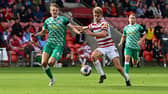 Doncaster's George Miller battles with Swindon's Tom Clayton.