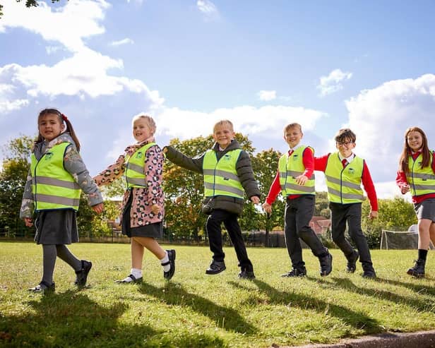 Chris Carlin, Marketing Manager Miller Homes Yorkshire, gives high-vis vests to children from year R to year 6 at Harworth Primary School