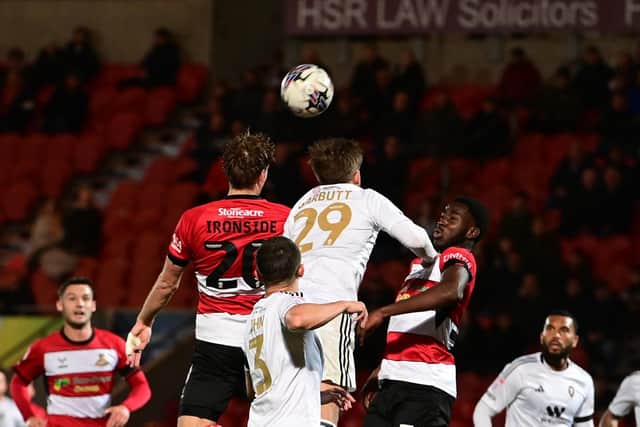Joe Ironside goes up for a header for Doncaster Rovers against Salford City.