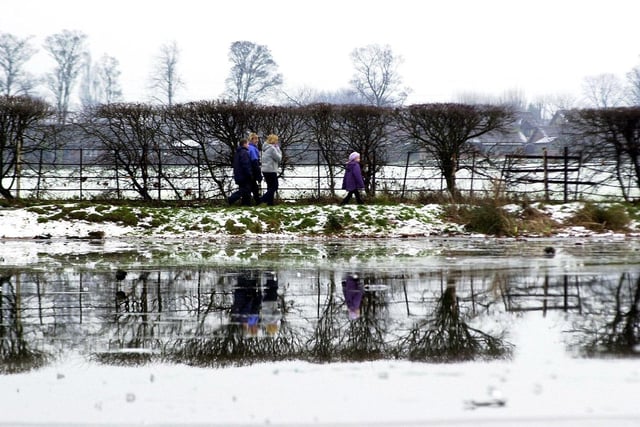 Visitors to Cusworth Park are reflected in the park's icy pond in January 2002