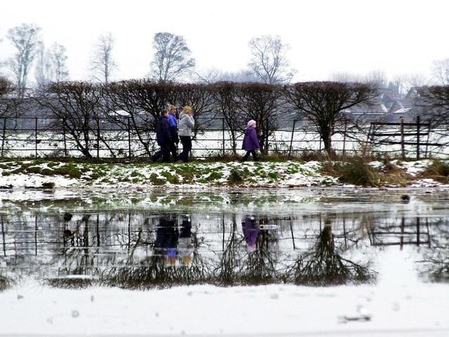 Visitors to Cusworth Park are reflected in the park's icy pond in January 2002