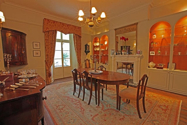 The dining room is situated to the rear of the house, has a fine timber floor, a fireplace flanked by glass display shelving with cupboards below and lighting above, pair of doors to the conservatory.