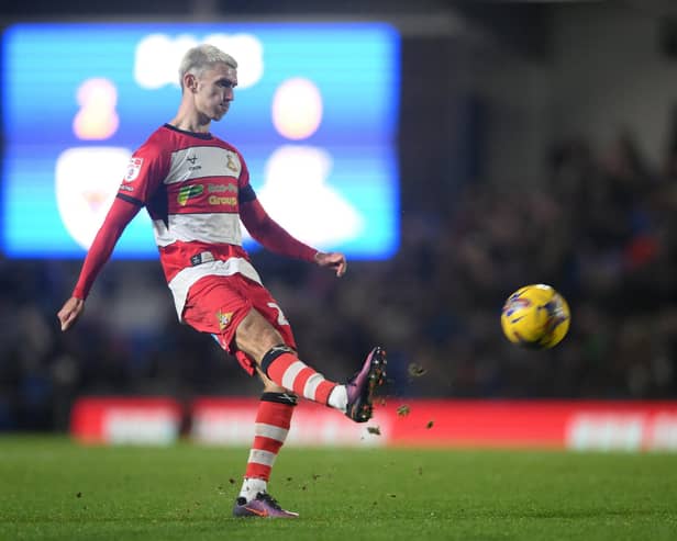 Doncaster Rovers midfielder Zain Westbrooke puts the ball into the box against AFC Wimbledon.