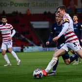 Doncaster's James Maxwell puts the ball into the six-yard box against Carlisle United.