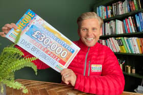 Lottery ambassador Jeff Brazier with one of the winning cheques