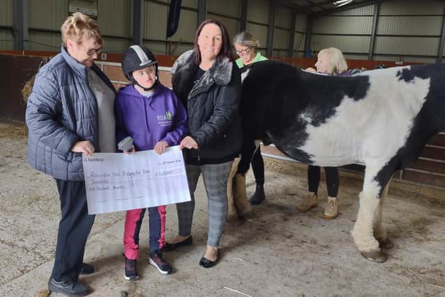 Trudy Lugg (third from right) presents Rossington Hall Riding for the Disabled Association with a cheque for £1,000