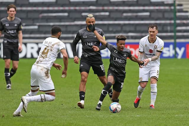 Jason Lokilo is pulled back by MK Dons' Josh McEachran. Picture: Gareth Williams/AHPIX