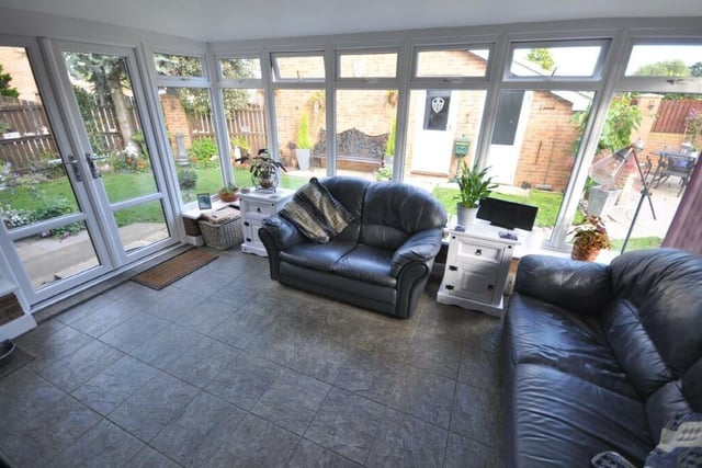 A spacious conservatory with French doors out to the garden.