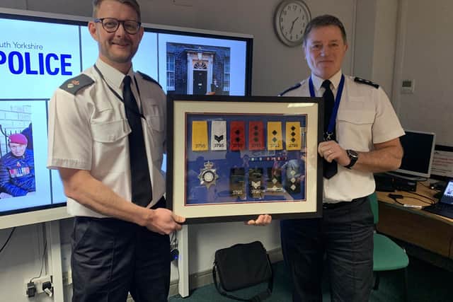 Doncaster District Commander and Chief Superintendent Ian Proffitt presents Chief Inspector David Struggles with a frame of epaulettes chronicling his policing career.