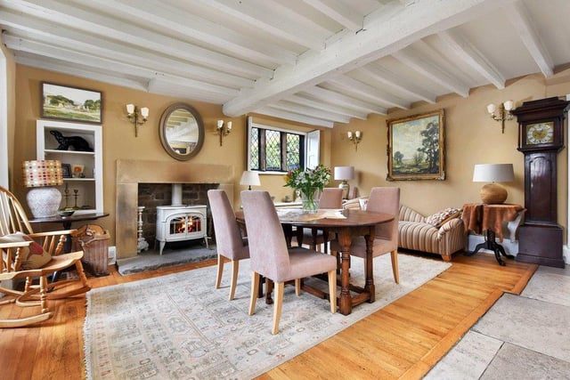 The reception hall has a large fireplace with heavy stone lintel and woodburner, a floor of flagstones and oak, exposed ceiling timbers and both stone mullion and sash windows.