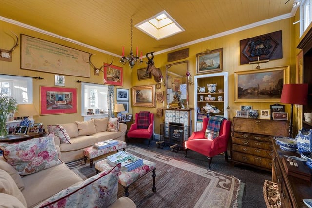 The sunny living room has a tiled fireplace and further views of the castle grounds.