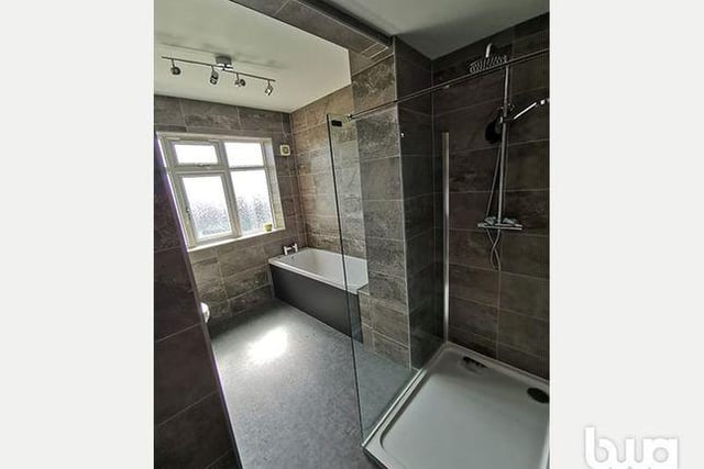 A modern bathroom comes fitted with a bath and walk-in shower as well as a toilet and wash basin.