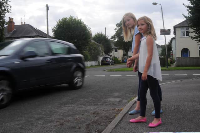 Charlotte and Emily watch a car speed by. Picture credit Rob Lacey.