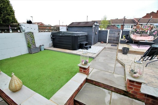 The front garden has raised areas of decking with an astroturf lawned section.
