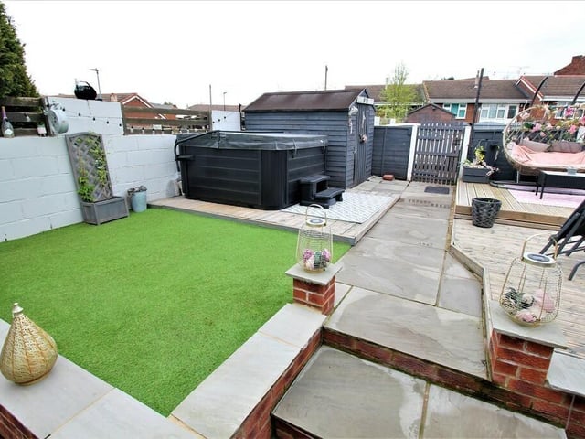 The front garden has raised areas of decking with an astroturf lawned section.