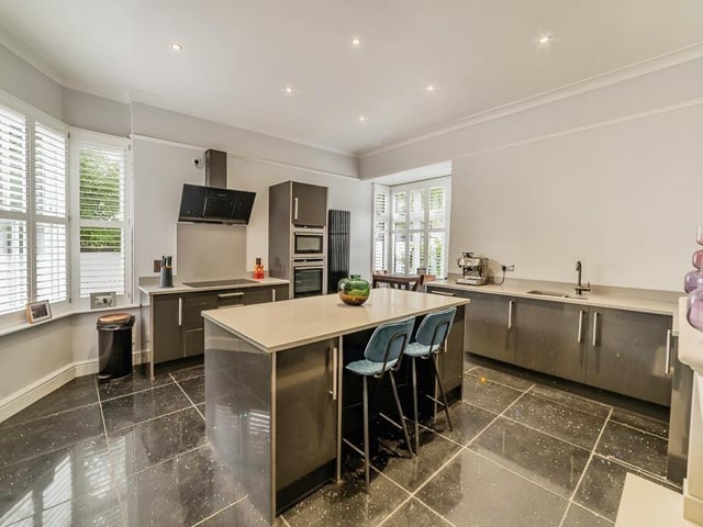 The modern kitchen with central breakfasting island.