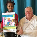 Zinnia and Brian Abrams with her winning design and prizes.