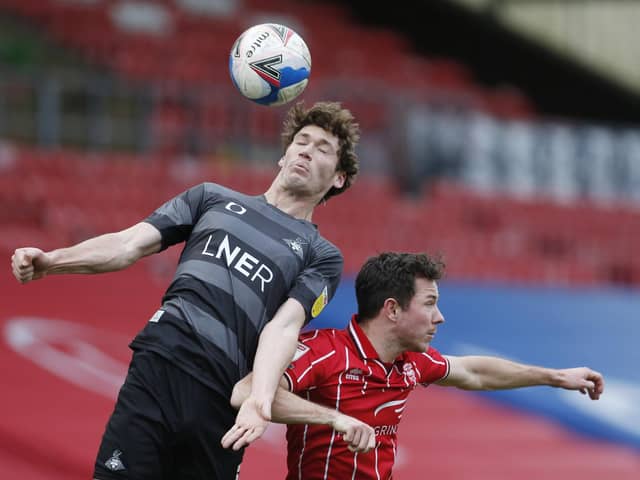 Joe Wright challenges Lincoln City's Joe Walsh. Picture: Craig Brough/AHPIX