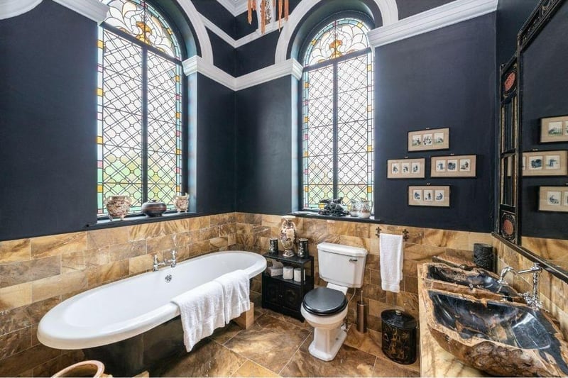 Another luxurious marble bathroom, with feature stained glass windows.