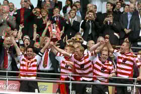 Rovers skipper Brian Stock lifts the trophy and leads the celebrations after victory in the play-off final at Wembley