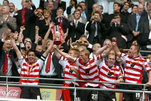 Rovers skipper Brian Stock lifts the trophy and leads the celebrations after victory in the play-off final at Wembley
