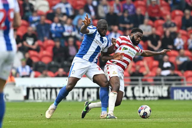 Doncaster's Ro-Shaun Williams battles with John Akinde.