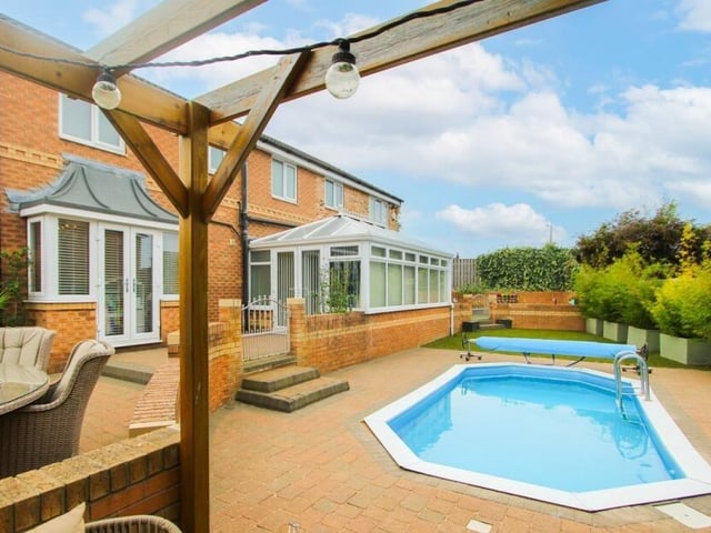 The heated swimming pool within the garden to the rear of the house.