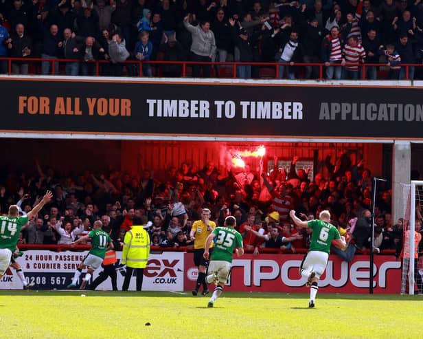 Doncaster Rovers players and fans celebrate James Coppinger's title-clinching goal.