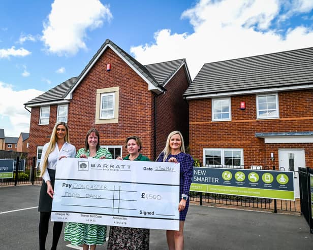 Barratt representatives hand over a giant cheque for £1,500 to Doncaster Foodbank