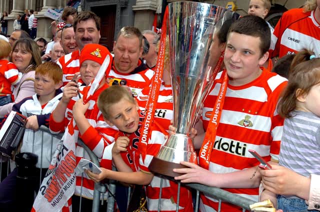 A fan gets up close and personal with the Johnstone's Paint Trophy.