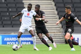 Joseph Olowu (centre) was subbed at half time at MK Dons.