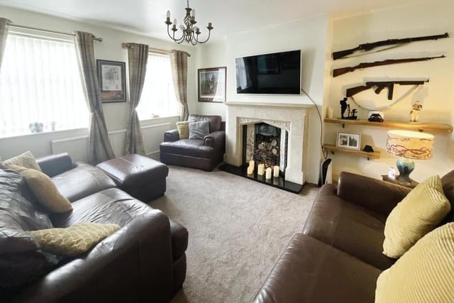 A bright sitting room, with feature fireplace and cosy log burner.
