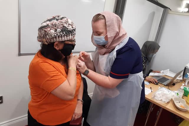 Nar Kumari Budha is vaccinated by nurse and Kayle Nazimek at Belle Vue Mosque in Doncaster