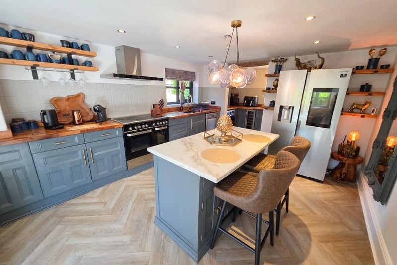 A granite-topped island is a feature in the centre of the well-equipped kitchen.