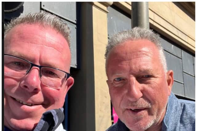 Sir Ian Botham poses for a photo with fishmonger James Mitchell.