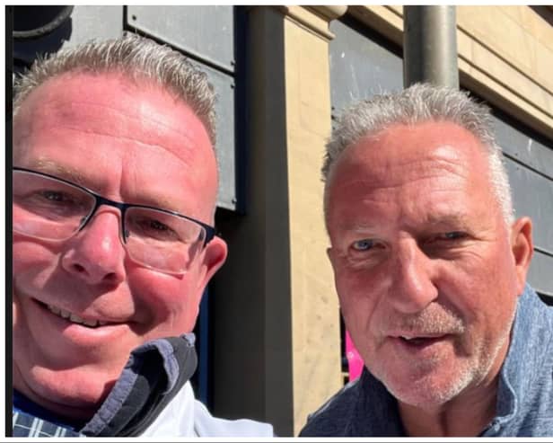 Sir Ian Botham poses for a photo with fishmonger James Mitchell.