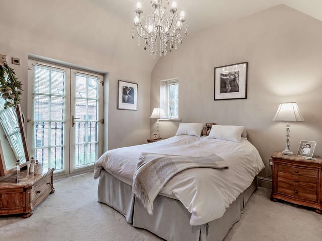 A double bedroom with doors that open to a balcony feature.