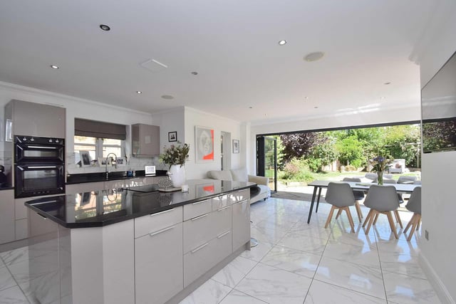 The modern kitchen is beautifully fitted and boasts a grand central island and breakfast bar at its heart, along with two sets of bi-folding doors which flood the room with natural light.