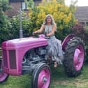 Gracie on her bright pink 80 year old Ferguson tractor