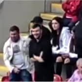 Two men were filmed making offensive gestures and apparently mocking a severely disabled Rotherham United fan.