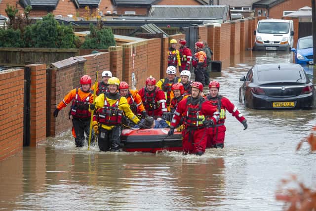 Archive picture from November 8, 2019. The RLNI and fire rescue officers pictured rescuing a man with one leg from a property on Yarborough Terrace on a flooded estate in Bentley, Doncaster after the River Don Burst its banks. Picture Tony Johnson