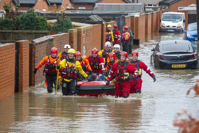 Archive picture from November 8, 2019. The RLNI and fire rescue officers pictured rescuing a man with one leg from a property on Yarborough Terrace on a flooded estate in Bentley, Doncaster after the River Don Burst its banks.   Picture Tony Johnson