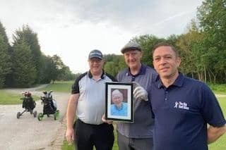 John and his brothers with a photo of their dad